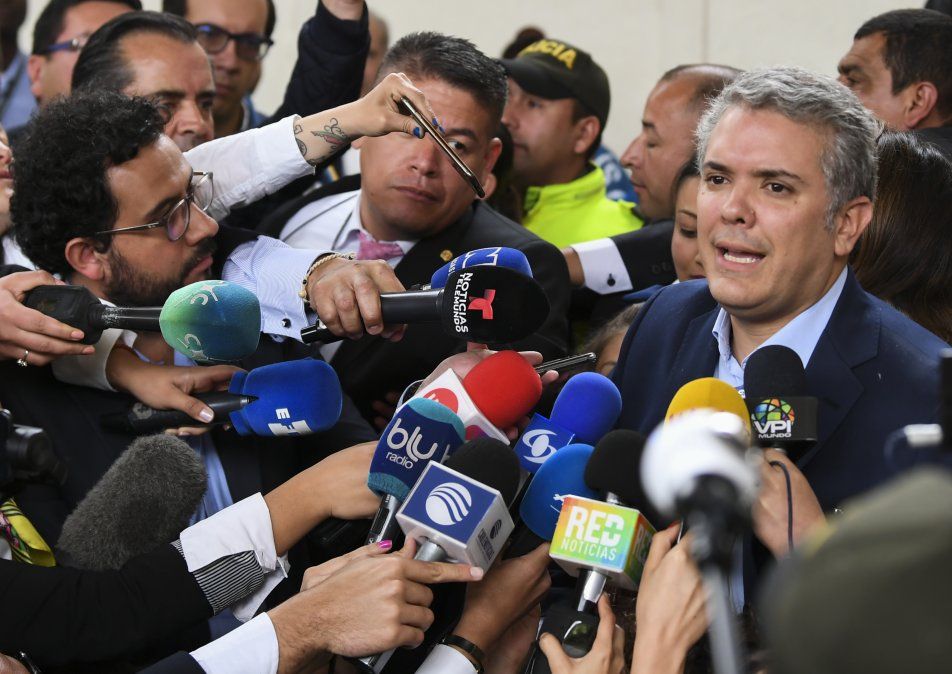 Presidenciable Iván Duque habla a la prensa en un centro de votación.