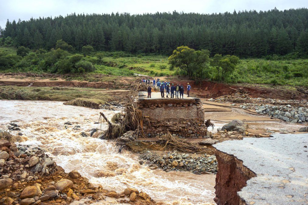 Trabajadores de la empresa Timber se quedan parados en un camino dañado luego que la zona fuera afectada por el ciclón que atravesó Mozambique y Zimbabwe. Trabajadores de la empresa Timber se quedan parados en un camino dañado luego que la zona fuera afectada por el ciclón que atravesó Mozambique y Zimbabwe.