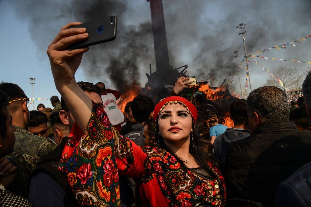Una mujer se toma una selfie frente a una hoguera mientras los jurdos turcos se reúnen durante las celebraciones para el año nuevo Una mujer se toma una selfie frente a una hoguera mientras los jurdos turcos se reúnen durante las celebraciones para el año nuevo