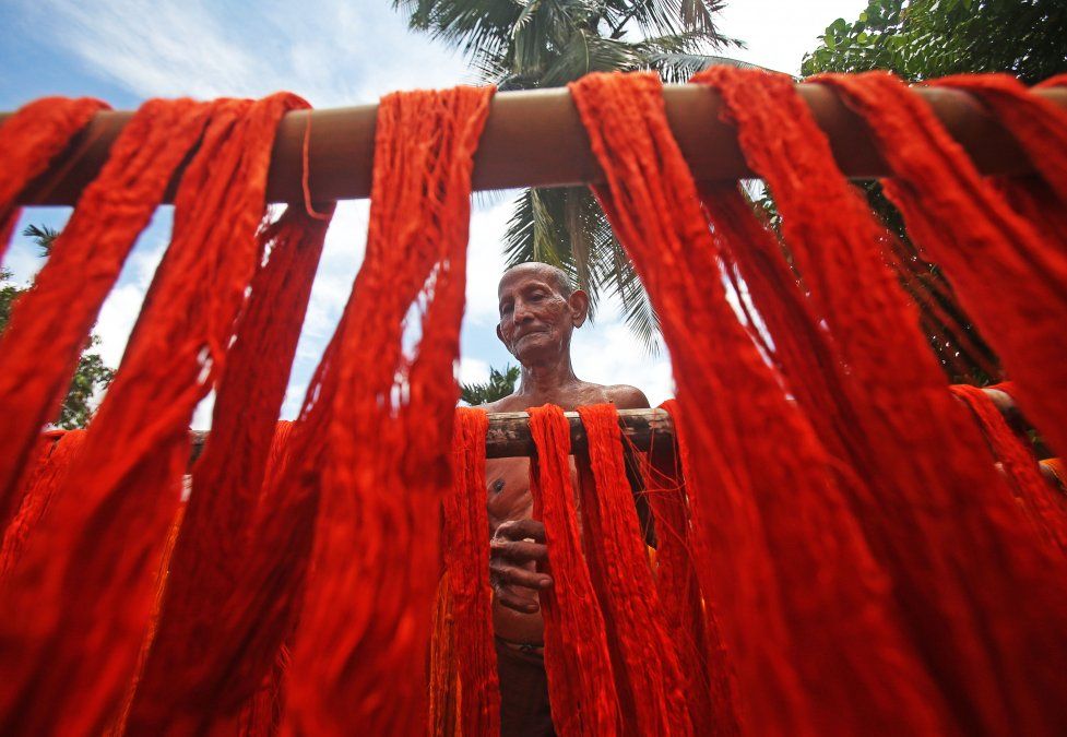 Un trabajador sostiene hilos teñidos para secar en una fábrica textil en las afueras de Agartala Un trabajador sostiene hilos teñidos para secar en una fábrica textil en las afueras de Agartala