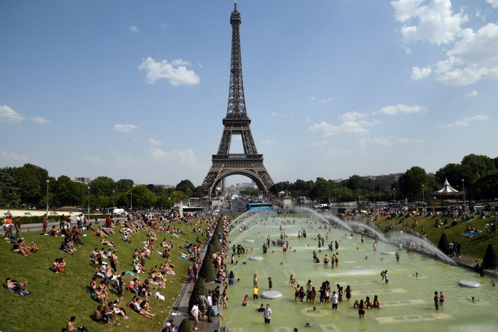 La gente se refresca y toma sol en la fuente Tricadero cerca de la Torre Eiffel en medio de la ola de calor que afecta a Europa La gente se refresca y toma sol en la fuente Tricadero cerca de la Torre Eiffel en medio de la ola de calor que afecta a Europa