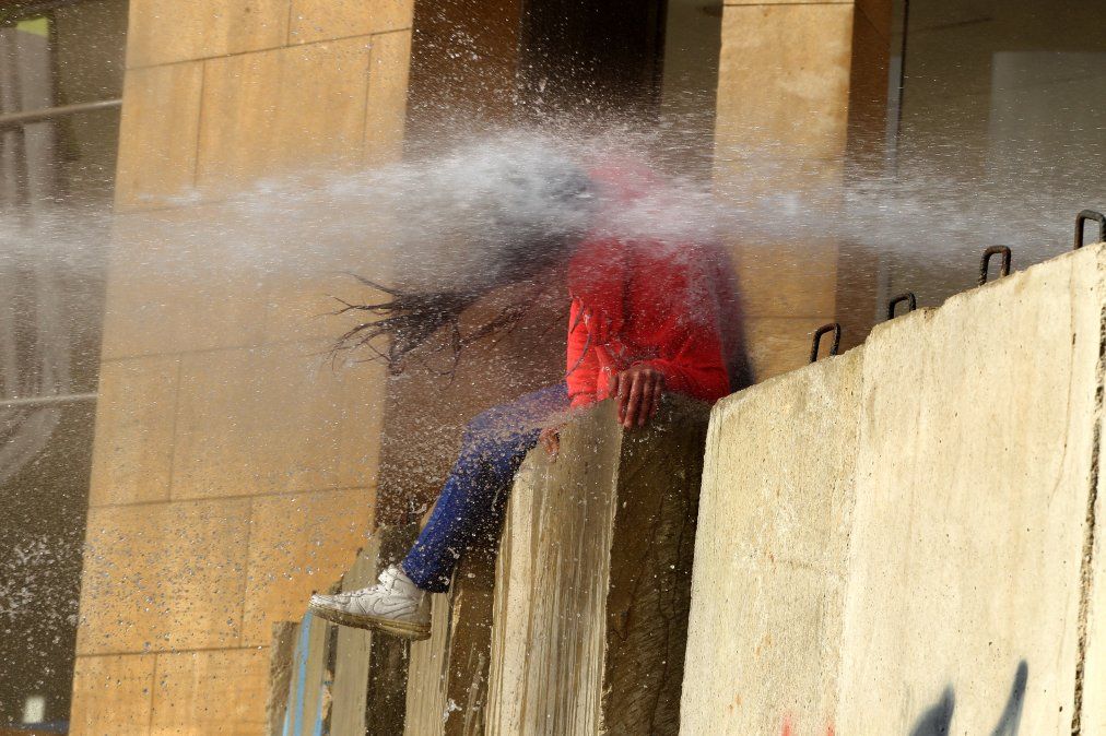 Un manifestante libanés es alcanzado por un cañón de agua durante los enfrentamientos con soldados del ejército Un manifestante libanés es alcanzado por un cañón de agua durante los enfrentamientos con soldados del ejército