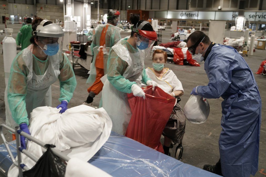 Miembros de la Defensa Civil trasladan un paciente en una camilla hacia el hospital Severo Ochoa, en Leganes