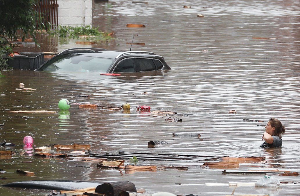 Una mujer intenta moverse en medio de las inundaciones que azotan a Lieja