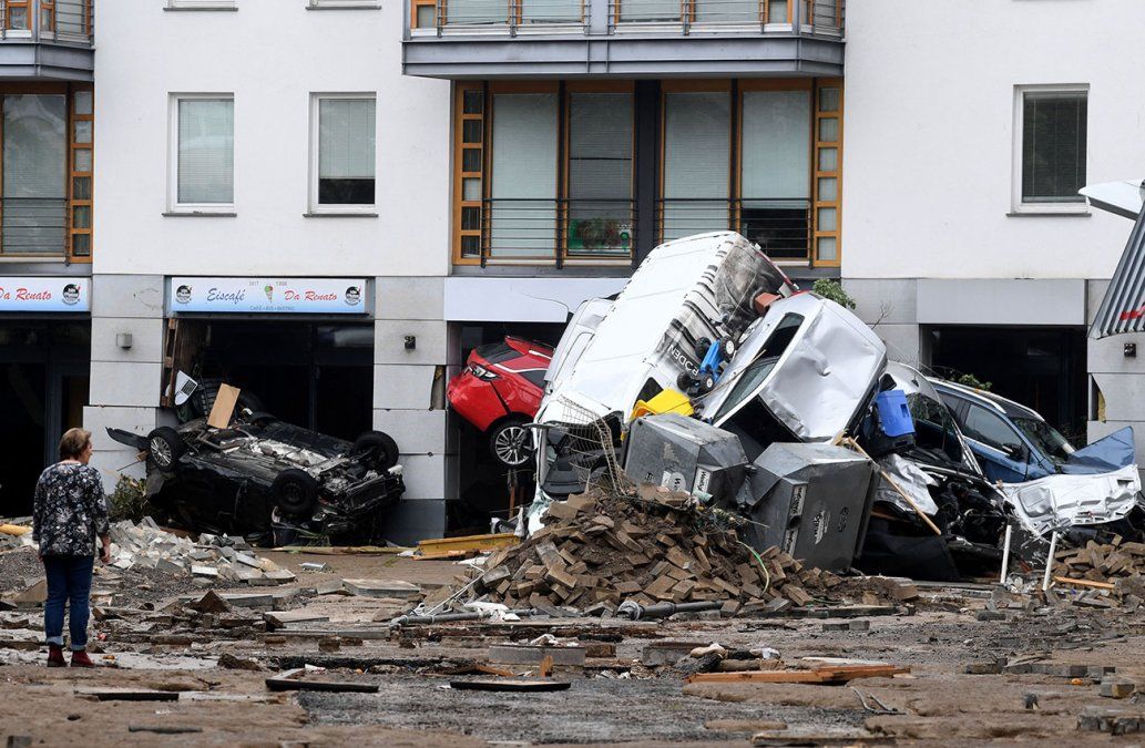 Una mujer mira automóviles y escombros amontonados en una calle después de que las inundaciones causaron daños importantes en Bad Neuenahr-Ahrweiler