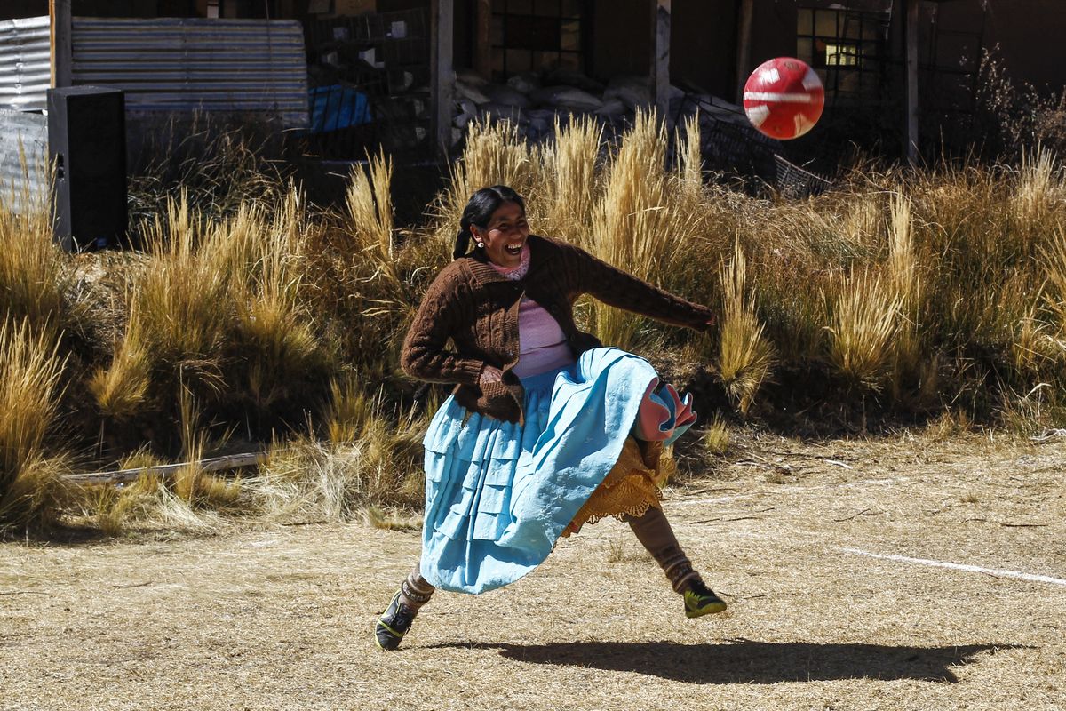 Una mujer indígena aymara juega al fútbol durante un campeonato en el distrito aymara de Juli en Puno, al sur de Perú, el 16 de julio de 2022. Foto: AFP