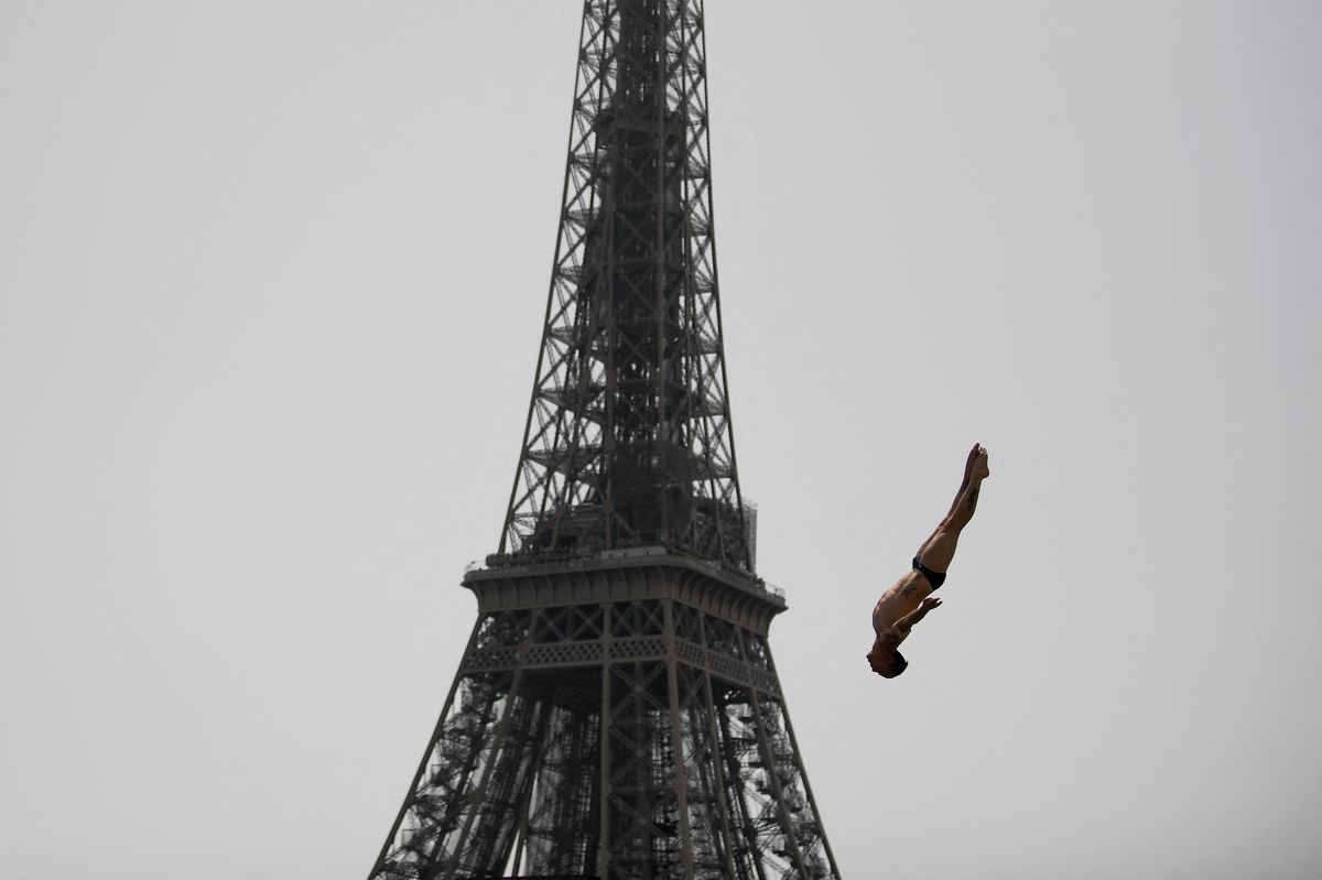 El francés Gary Hunt realiza una inmersión de práctica durante la Serie Mundial Red Bull Cliff Diving cerca de la Torre Eiffel en París, el 18 de junio de 2022. Foto: AFP.