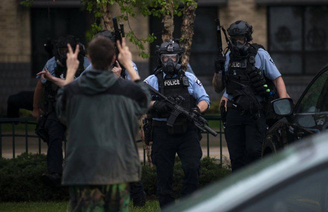 Foto: AFP. Un joven fotografiado frente a policías el 26 de mayo de 2020 en Minneapolis, Minnesota, durante una protesta por la muerte de Floyd. &nbsp;