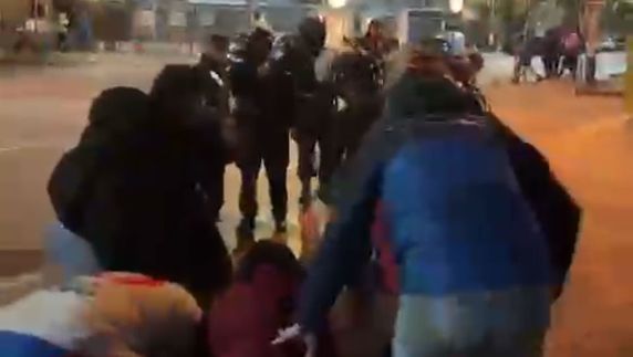 Foto: captura de video del momento que hinchas llevan al herido hasta el vallado policial. Video compartido en redes sociales.