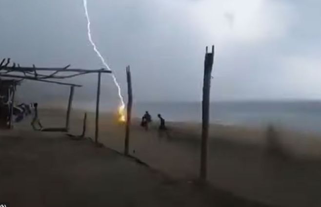 El rayo en el momento que impacta sobre una de las personas en la playa. Foto: captura de pantalla del video que captó el momento.