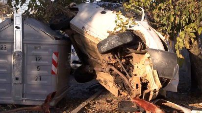 espectacular accidente: un auto despisto, choco un muro y termino arriba de un contenedor