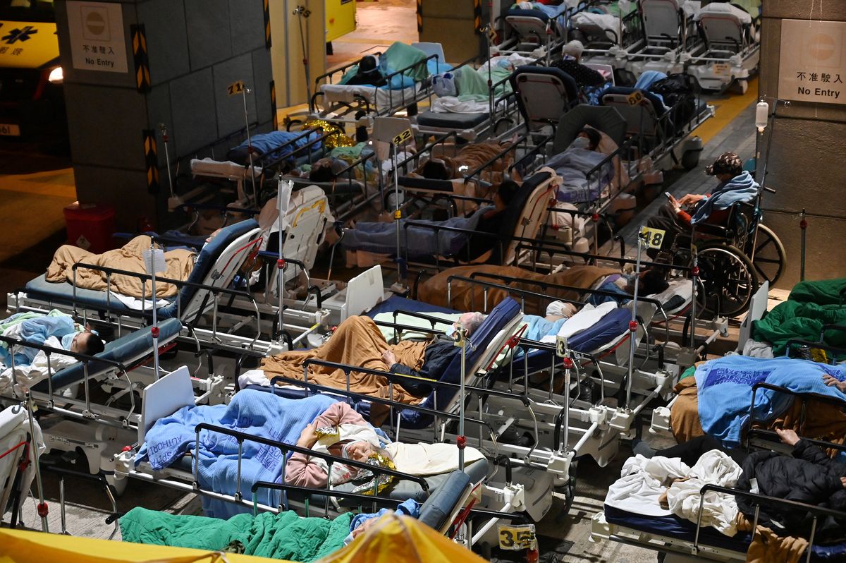 Personas yacen encamas de hospital fuera del Centro Médico Caritas en Hong Kong, yaque los hospitales están repletos, en esta ciudad que enfrenta supeor ola de coronavirus hasta la fecha.
