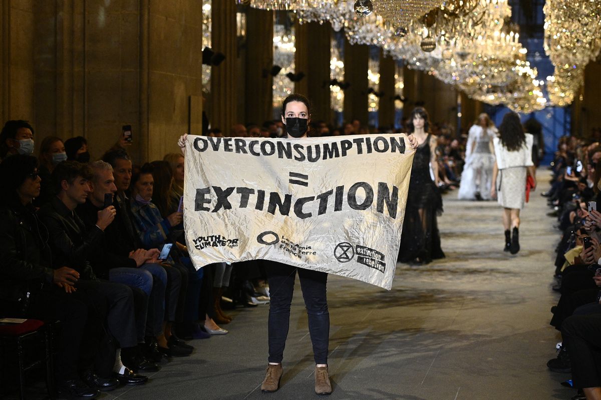 Un activista de Extinction Rebellion irrumpe en el desfile de Louis Vuitton en el Louvre para denunciar el impacto de la industria de la moda en el cambio climático, el último día de la Semana de la Moda de París.