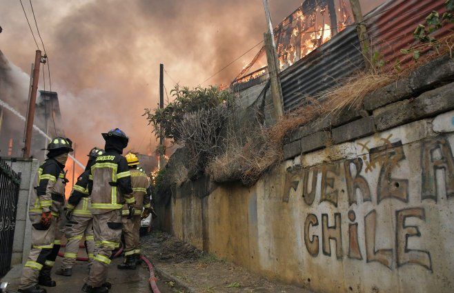 Foto: AFP. Bomberos intentan combatir llamas en el sur de Chile ante incendios.