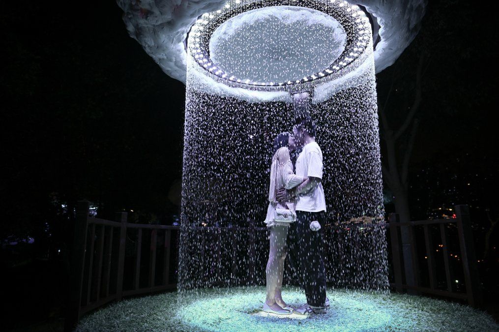 Una pareja se besa en una muestra que busca&nbsp;la inmersión en la luz al aire libre, durante el Festival Internacional de la Luz de Beijing 2020.
