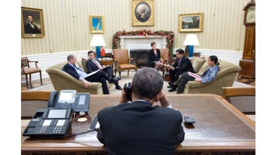 Barack Obama conversa con Raúl Castro antes de realizar el anuncio del desbloqueo.