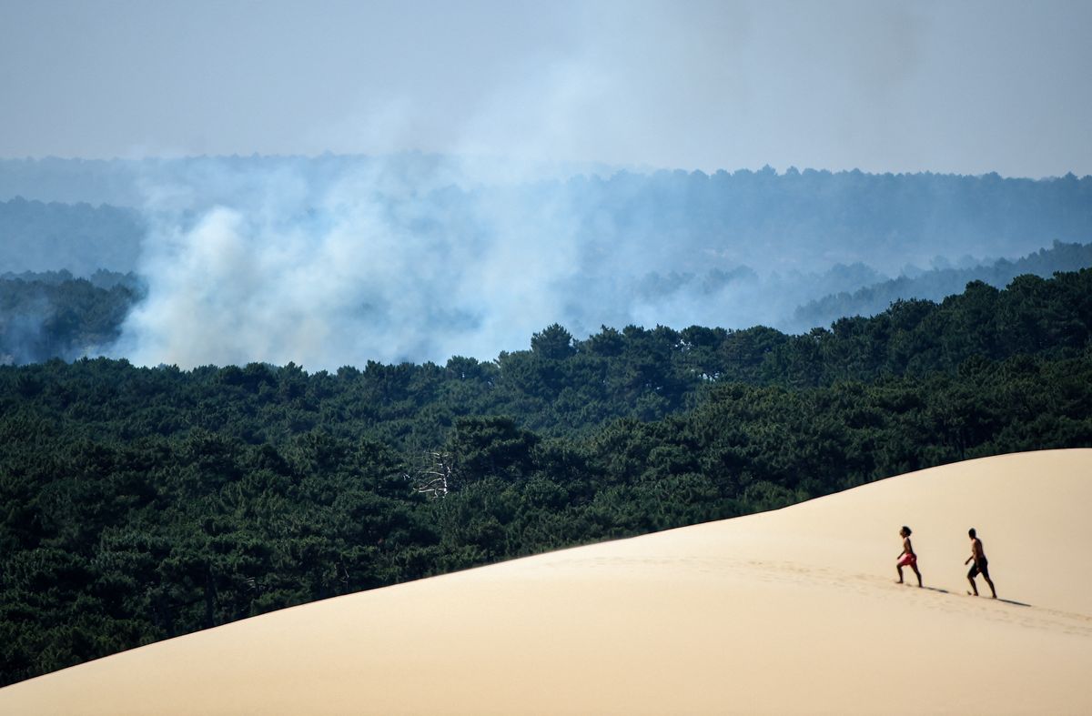 Personas caminan sobre la Duna de Pilat (Dune du Pilat) cerca de La Teste-de-Buch, suroeste de Francia, el 16 de julio de 2022. La intensa movilización de bomberos no decayó el 16 de julio de 2022 para apagar los incendios en el sur de Francia. Foto: AFP