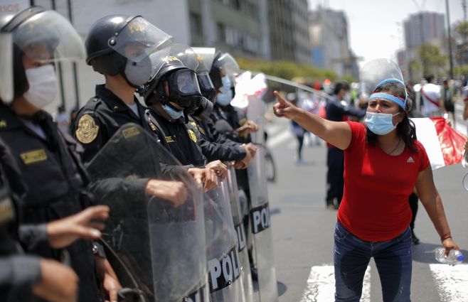 Una manifestante provoca a la Policía durante la celebración frente al Congreso peruano, al conocerse la noticia de la renuncia de Manuel Merino como presidente interino de Perú