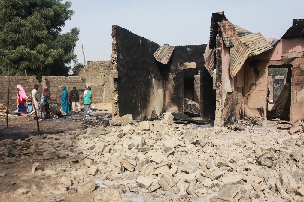 Un grupo de niños camina cerca de los restos de una casa tras un ataque en la villa Sajeri a manos del grupo armado Boko Haram.