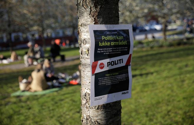 Cartel de la Policía en un parque de Aarhus, Dinamarca, en el que anuncia que esa zona puede ser cerrada por prevención del Covid-19. Foto: AFP.