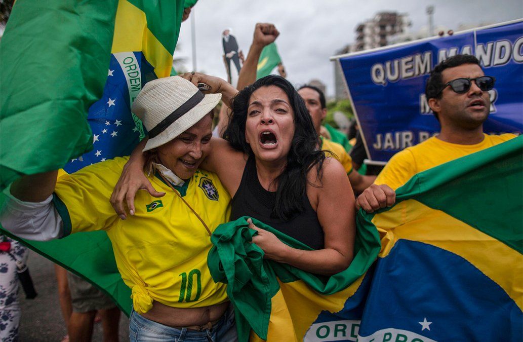 Simpatizantes del candidato del Partido Social Lineral Jair Bolsonaro celebran frente al condominio donde vive.&nbsp;