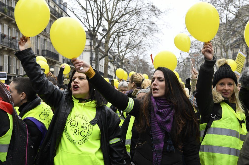 Mujeres marchan con globos amarillos durante la movilización cerca de La Bastilla en París.