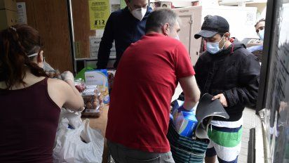 Los voluntarios de la Asociaci&oacute;n de Vecinos de Aluche (AVA) reparten raciones de alimentos a personas en riesgo de exclusi&oacute;n social en Madrid