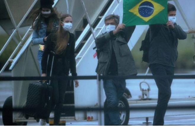 Pasajeros salen de uno de los aviones en los que fueron repatriados de la ciudad china de Wuhan 34 brasileños y sus parientes, tras aterrizar en una base de Anápolis (Brasil)