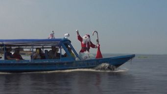 papa noel entrega regalos en barco a ninos de comunidades indigenas del amazonas