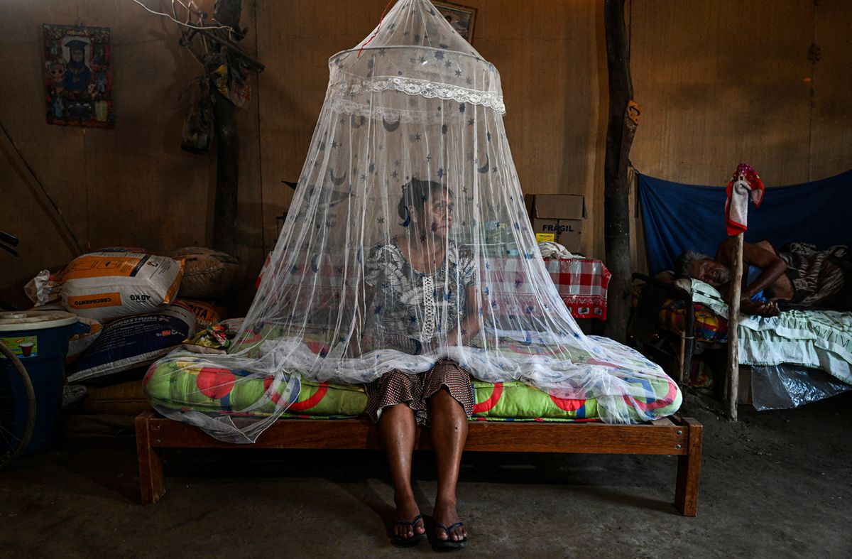 Francisca Sosa (45) posa para una fotografía junto a su padre, quien sufre de fiebre del dengue, en su casa en el distrito de Catacaos, departamento de Piura, Perú, el 9 de junio de 2023.