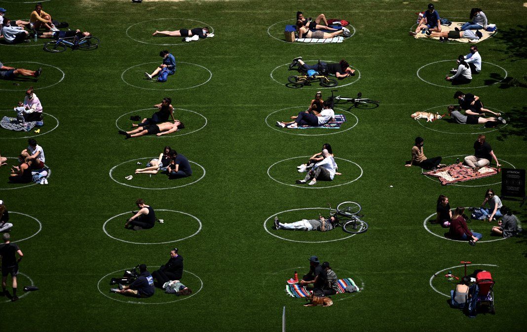 La gente es vista manteniendo distancia social dentro de círculos en el parque Domino de Brooklyn