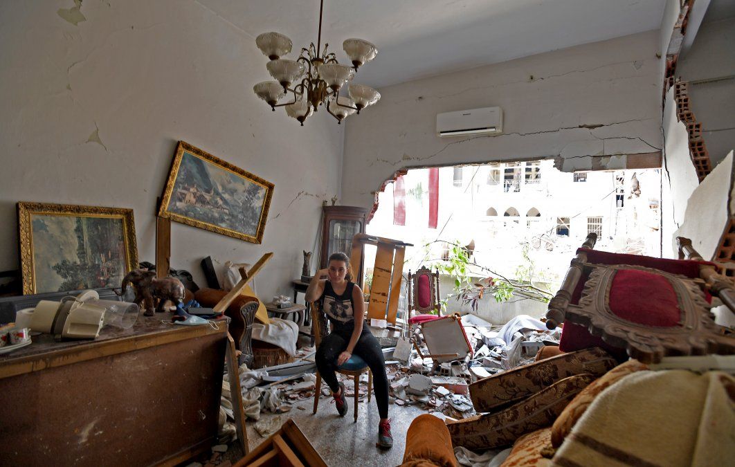 Una mujer sentada entre los escombros de su casa dañada dos días después que una explosión sacudiera la capital libanesa