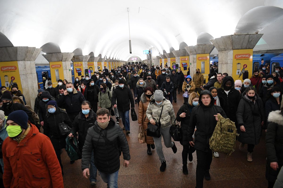 Personas, algunascon bolsos y maletas, caminan en una estación de metro en Kiev aprimera hora del 24 de febrero de 2022.