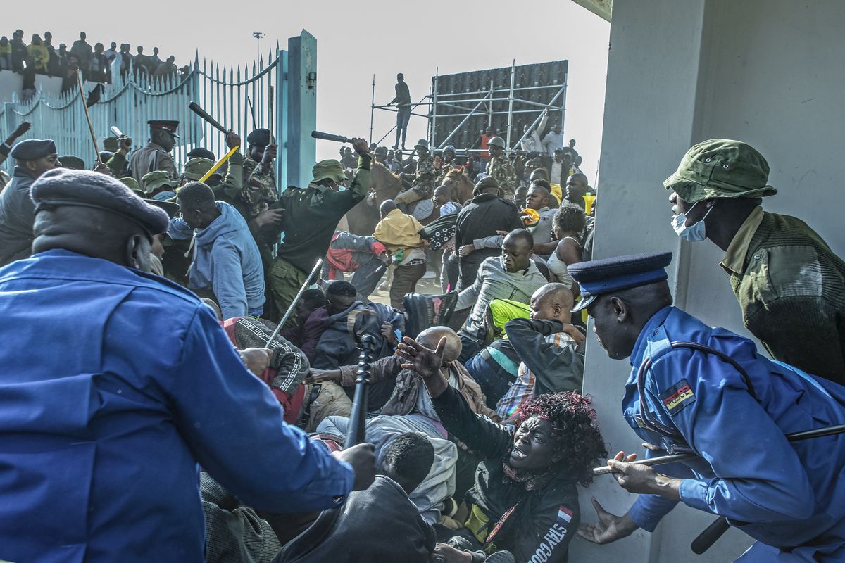 Una mujer pide ayuda mientras las fuerzas de seguridad de Kenia intervienen durante una estampida en la entrada del Moi International Sports Center Kasarani en Nairobi, Kenia, el 13 de septiembre de 2022 antes de la ceremonia de inauguración de William Ruto. Foto: AFP