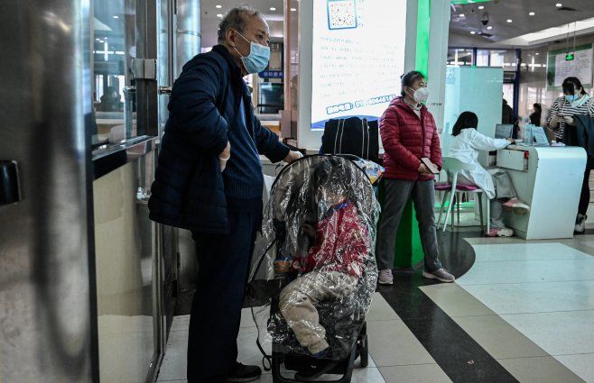 Foto: AFP. Los niños y sus padres esperan en un área ambulatoria de un hospital infantil en Beijing, el 23 de noviembre de 2023.