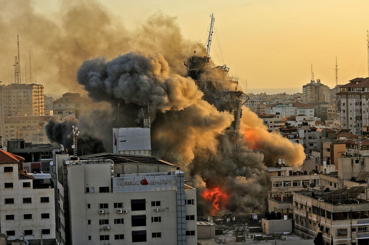 Denso humo y fuego se elevan desde la torre de Al-Sharouk mientras se derrumba después de ser golpeada por un ataque aéreo israelí