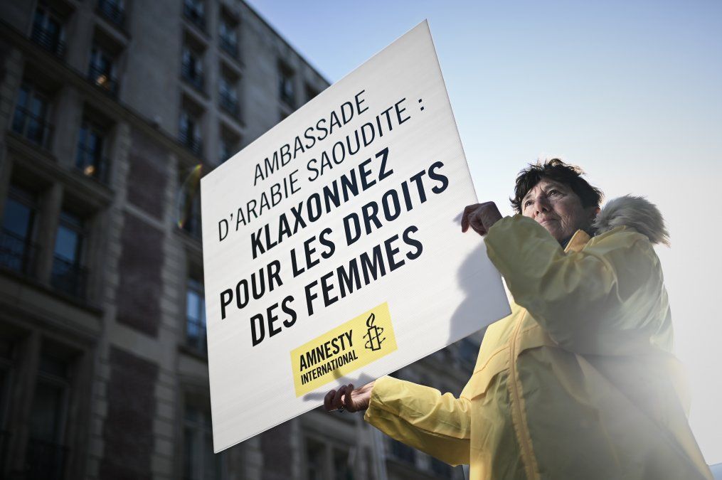 Una mujer sostiene un cartel que dice Embajada de Arabia Saudita: toque por los derechos de las mujeres mientras participa en una manifestación organizada por Amnistía Internacional fuera de la embajada de Arabia Saudita en París.
