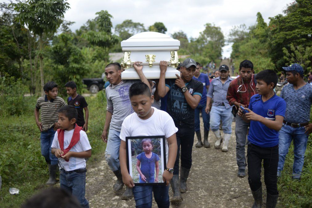 Un niño lleva una imagen de la niña guatemalteca de 7 años que falleció en Texas dos días después de ser tenida en custodia por la patrulla fronteriza estadounidense