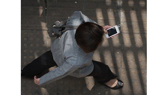 Gente camina celular AFP