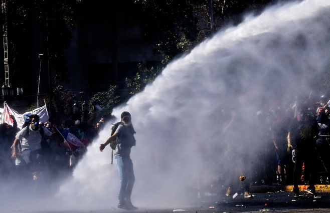 Manifestantes son rociados con agua por la Policía militarizada chilena.&nbsp;