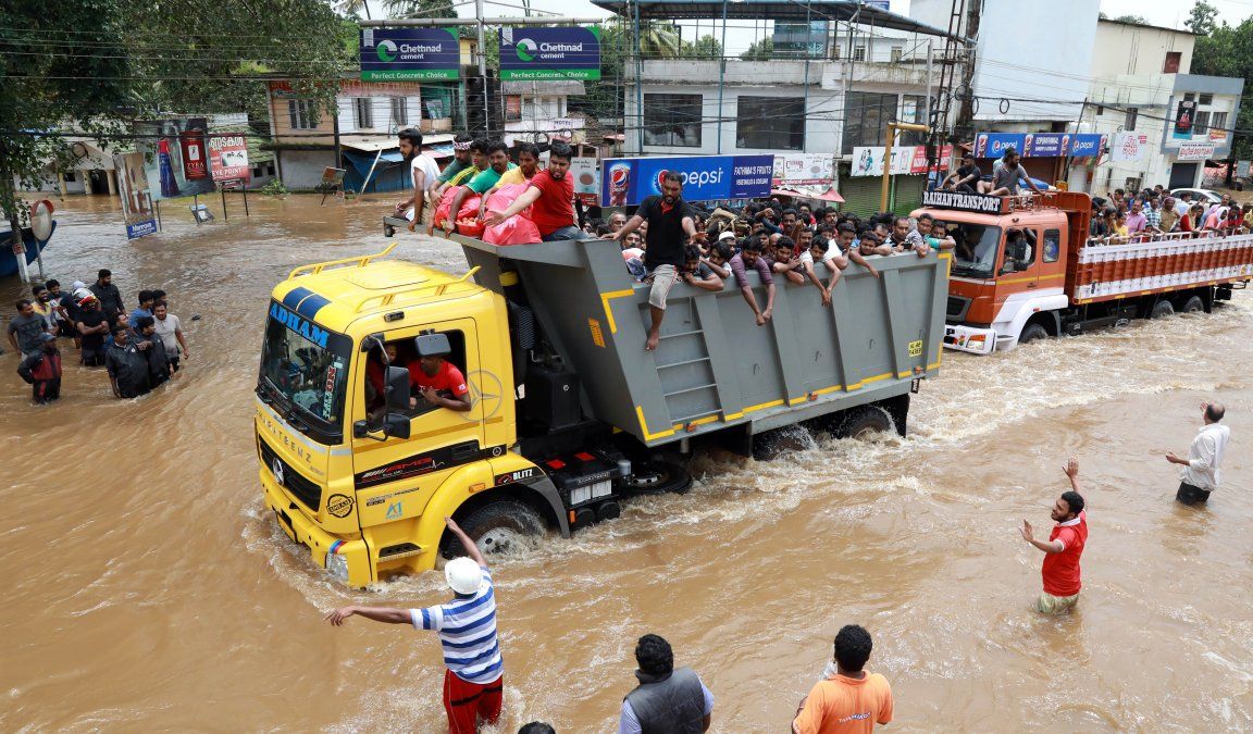 Pasajeros indios van en un camión hacia un lugar seguro mientras se han encontrado más de 100 cuerpos en un día por las inundaciones.