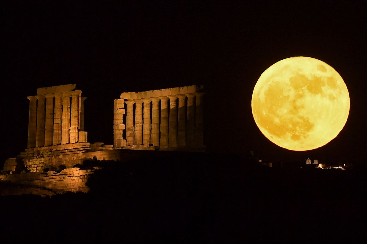 Esta fotografía muestra una luna llena, conocida como la Luna de fresa, detrás del Templo de Poseidón en Cabo Sounion, al sur de Atenas.