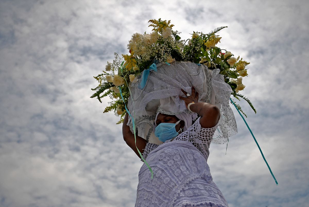 Un miembro de Filhosde Gandhi, un grupo religioso afrobrasileño, lleva una ofrenda enhonor a Yemanjá, la diosa del mar, en Río de Janeiro, el 2 defebrero.&nbsp;&nbsp;