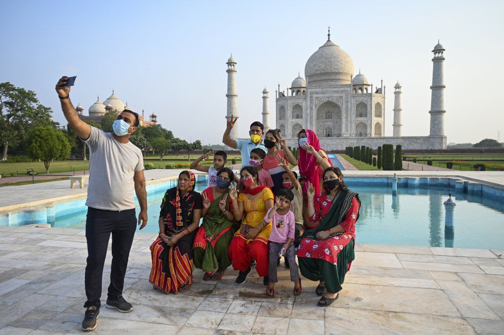 Un grupo de turistas toma fotos en el Taj Mahal después de que reabriera a los visitantes
