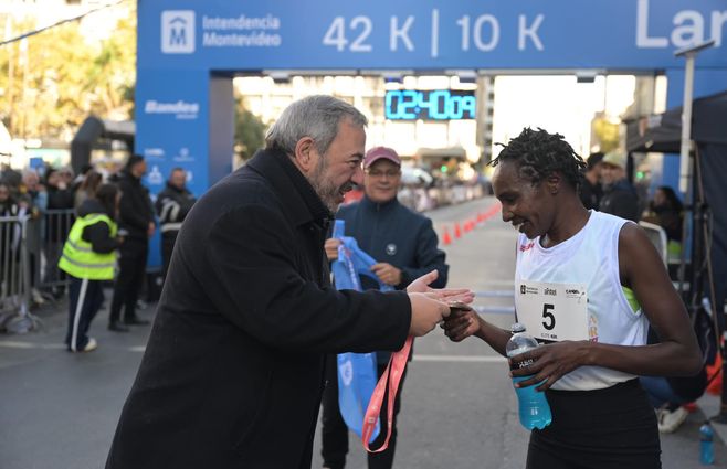 Bergara entrega la medalla a uno de los competidores en la maratón de esten domingo. Foto: Intendencia de Montevideo. 