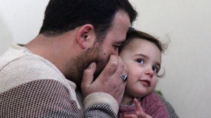 un padre sirio ensena a su hija a reir cada vez que cae una bomba