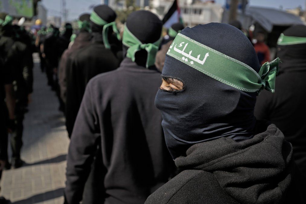 Militantes palestinos enmascarados participan en una manifestaci&oacute;n, convocada por varios grupos en Gaza, para protestar contra el plan de paz negociado por Estados Unidos, en Gaza.