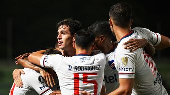 Francisco Ginella (al fondo) celebra con sus compañeros de equipo después de marcar durante el partido de fútbol de la fase de grupos de la Copa Libertadores, frente a Metropolitanos. Foto: AFP