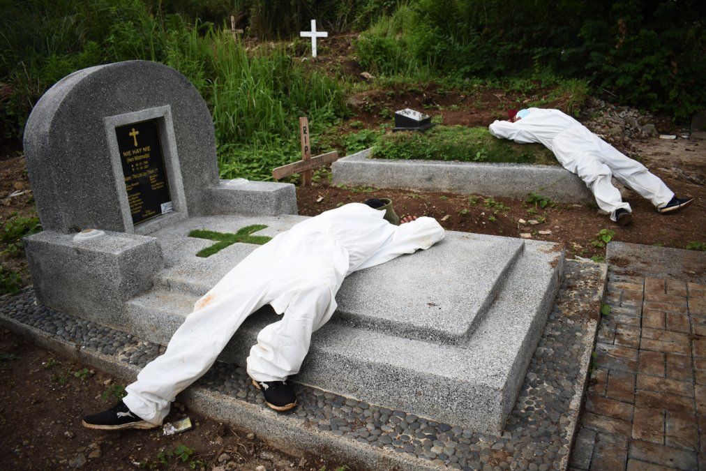 Exhaustos excavadores de tumbas descansan entre los funerales en un cementerio designado para las víctimas de Covid-19 en Bandung, Indonesia 
