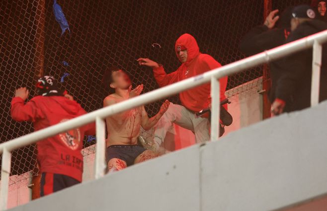 Hinchas de Independiente agreden a uno de la Universidad de Chile. AFP